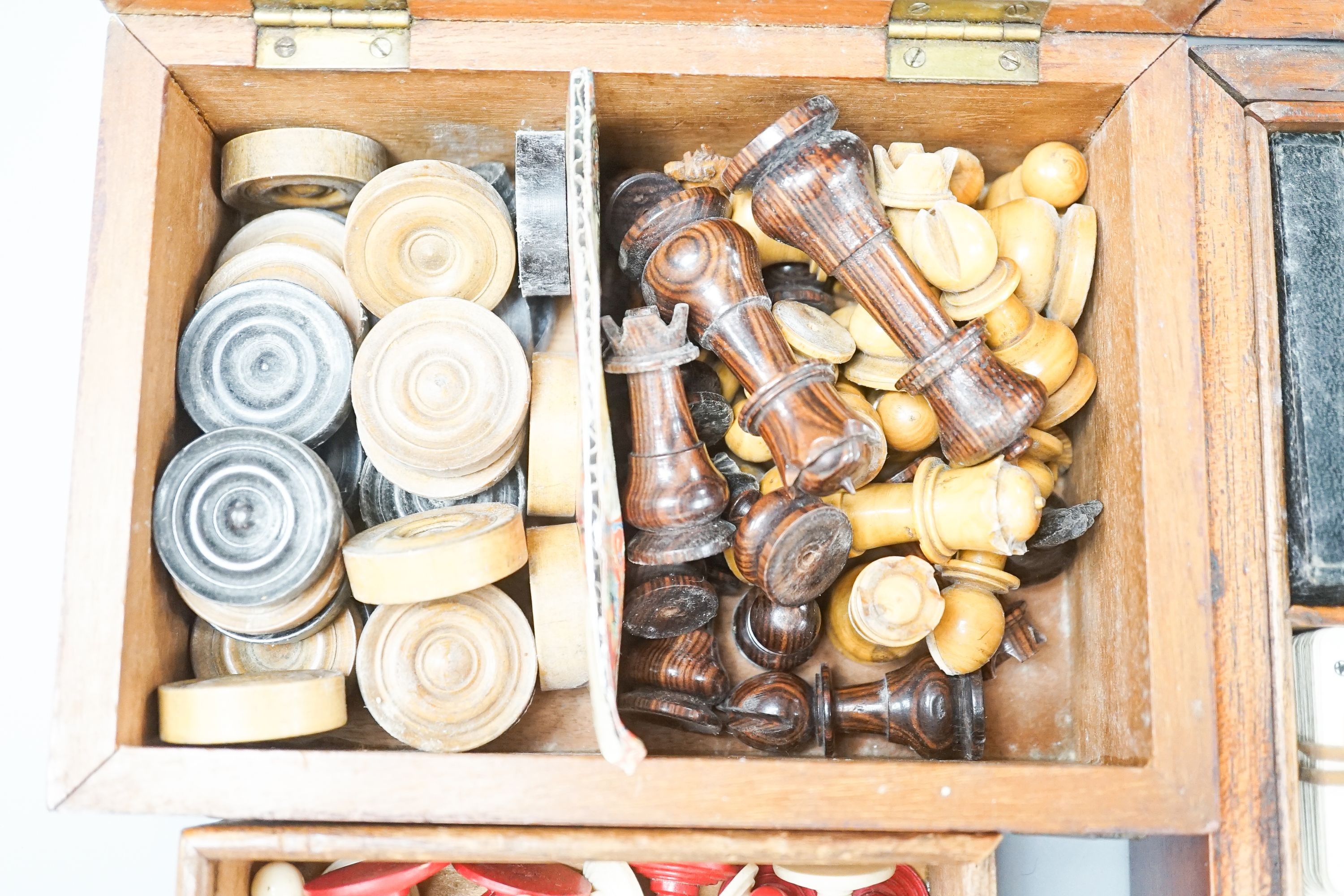 A Victorian brass inset mahogany games box, fitted with solitaire, cribbage, chessmen, draughts etc., 33cm, a turned and stained bone chess set, another games box containing chessmen and draughts